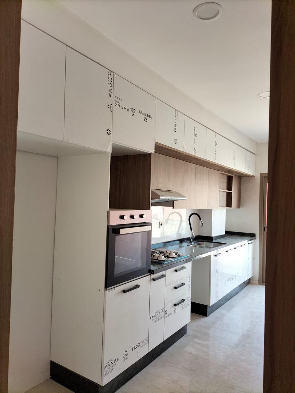 Cuisine linéaire blanche et bois en cours de pose